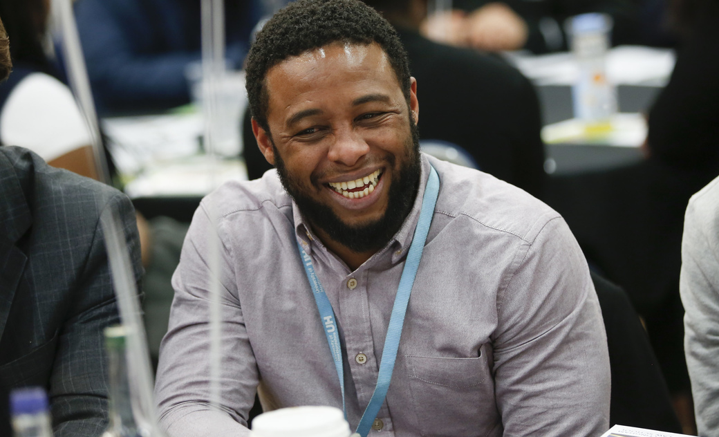 male student at a conference smiling