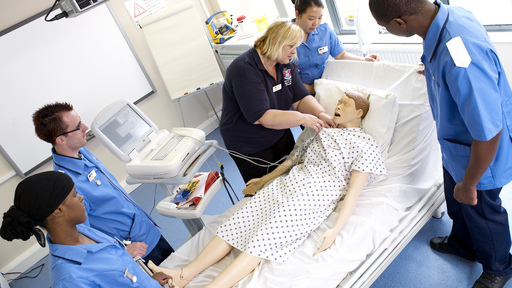 Medical students tending  a patient mannequin