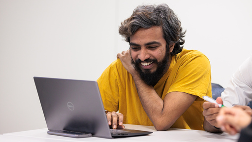 Person sat at a table, working on a laptop