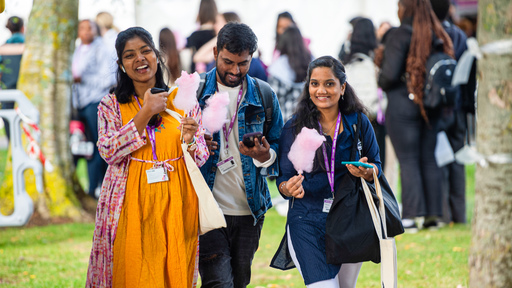 Students at an outdoor event eating candy floss