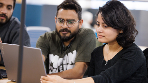 Students talking around a laptop