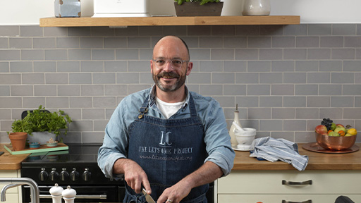 Male standing at kitchen counter ready to cook