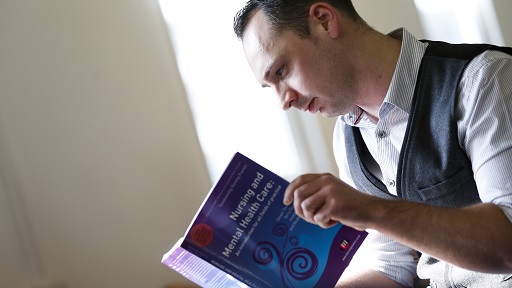 A student reading a book about mental health